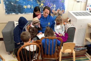 PreSchool family teacher reading to children