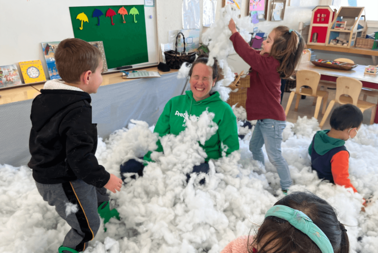 Children playing with pillow stuffing having a pillow fight