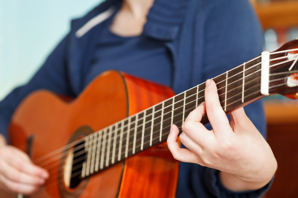 girl playing acoustical guitar
